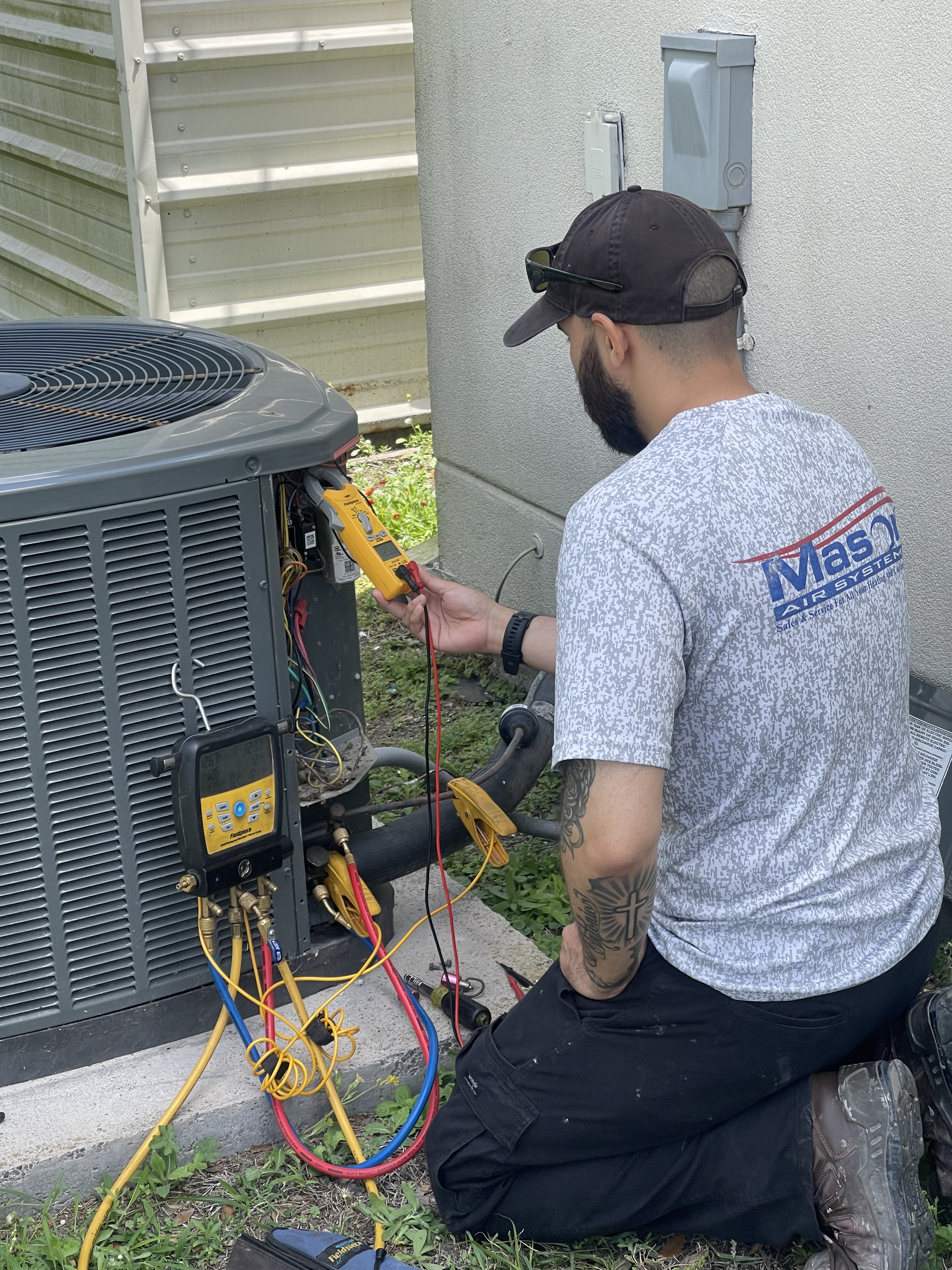 Mason Air Systems technician servicing an air conditioner at a South Texas coastal home