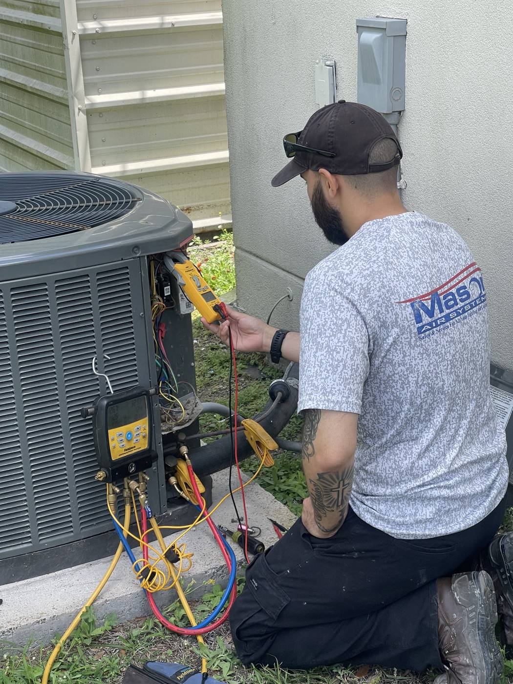 Mason Air Systems technician servicing an air conditioner at a South Texas coastal home