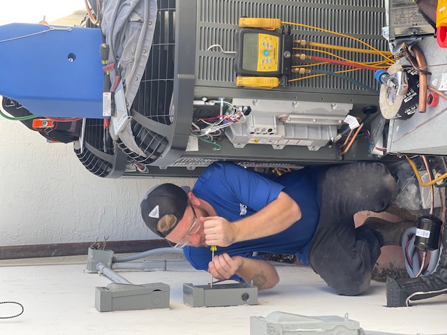 Mason Air Systems technician repairing an outdoor AC condenser unit in Corpus Christi
