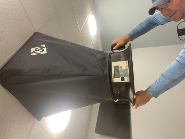 Mason Air Systems measuring air flow with a balometer hood at a commercial building